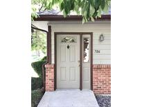 Charming home entrance featuring a light gray front door with decorative glass and brick accents and the house number 706 at 11041 Huron St # 706, Northglenn, CO 80234