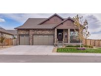 Charming stone home with a three-car garage and inviting front porch at 15804 Elizabeth Cir, Brighton, CO 80602