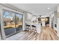Bright kitchen with white cabinets, granite countertops, stainless steel appliances, and sliding glass door to backyard at 9749 Meade Cir, Westminster, CO 80031