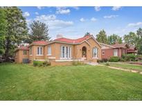 Charming stucco home with a red tile roof and a well-maintained lawn at 1295 S Downing St, Denver, CO 80210