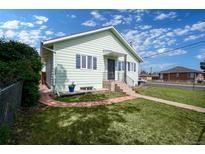 Charming home featuring a well-maintained lawn, brick-lined flower beds, and inviting curb appeal at 1391 Elmira St, Aurora, CO 80010