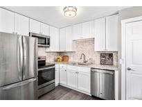 Updated kitchen featuring stainless steel appliances, granite countertops, and modern white cabinetry at 1391 Elmira St, Aurora, CO 80010