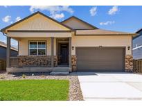 Charming single-Gathering home with a covered front porch and a two-car garage, showcasing great curb appeal at 845 Leeward St, Lochbuie, CO 80603