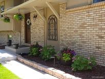 Charming brick home with flower baskets and front porch at 1095 Lake Woodmoor Dr, Monument, CO 80132