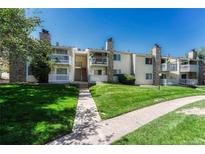 Inviting condo exterior with well-maintained lawn and stone accents, under a clear blue sky at 8555 Fairmount Dr # G103, Denver, CO 80247