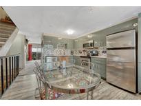 Modern kitchen features updated appliances, cabinets, and backsplash plus a glass top kitchen table with chairs at 14034 E Utah Cir, Aurora, CO 80012