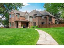 Stunning brick home featuring a lush lawn and stone walkway leading to the front entrance at 290 Dexter St, Denver, CO 80220