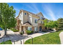Beautiful two-story townhome featuring stone accents, manicured lawn, and a welcoming facade at 494 Black Feather Loop # 108, Castle Rock, CO 80104