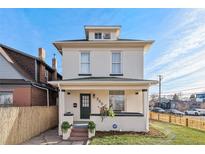 Inviting two-story home with a covered front porch, green lawn, and classic architectural details under a bright blue sky at 300 Inca St # A, Denver, CO 80223