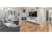 Inviting living room with hardwood floors, fireplace, and sliding door to a private balcony at 8465 Pebble Creek Way # 102, Highlands Ranch, CO 80126