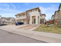 Charming two-story townhome featuring a balcony, attached garage, and inviting front entrance at 13000 W Grant Cir # C, Thornton, CO 80241