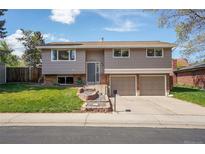 Charming two-story home with a manicured lawn, beautiful terraced garden, and an attached two-car garage at 9099 W Harvard Pl, Lakewood, CO 80227