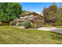 Inviting two-story home featuring an attached garage, lush landscaping, and a well-manicured lawn at 9951 Winona St, Westminster, CO 80031