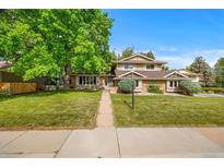 Charming home with lush green lawn, mature tree, and inviting walkway to the front door at 9951 Winona St, Westminster, CO 80031