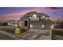 Charming two-story home featuring a three-car garage, brick accents, and a beautifully landscaped front yard at 6911 Chestnut Ct, Parker, CO 80134