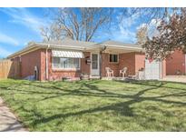 Charming brick home with a well-manicured lawn and inviting front porch, perfect for relaxing at 3022 Blackhawk St, Aurora, CO 80011
