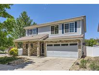 Charming two-story home featuring stone accents, blue shutters, and a well-manicured front yard at 18807 E 51St Pl, Denver, CO 80249