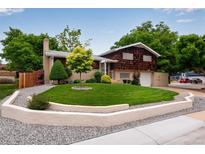 Charming home featuring a well-manicured lawn, stone accents, mature trees, and a brick and wood exterior at 147 Wallace St, Northglenn, CO 80234