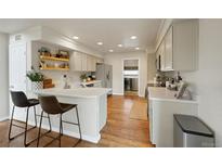 Updated kitchen with light-colored cabinets, quartz countertops, bar seating, and stainless steel appliances at 20000 Mitchell Pl # 9, Denver, CO 80249