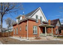 Charming brick home features a covered front porch, white trim, and a well-maintained yard at 4403 Alcott St, Denver, CO 80211