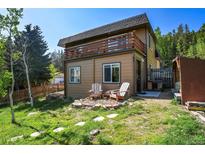 Charming exterior featuring a balcony, patio with chairs, and a beautifully landscaped yard at 63 Sillasen Ln, Golden, CO 80403