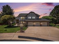 Stunning two-story home featuring a manicured lawn and a three-car garage at dusk at 16301 E Ida Ave, Centennial, CO 80015