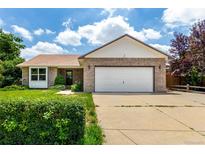 Charming brick home with a well-maintained front lawn and an attached two-car garage at 1015 S Fulton Ave, Fort Lupton, CO 80621