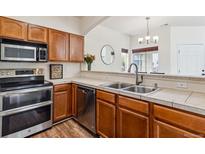 Modern kitchen with stainless steel appliances and wood cabinets at 1385 S Chambers Rd # 104, Aurora, CO 80017