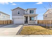 Charming two-story home with a well-manicured lawn, attached garage, and inviting front porch at 4206 Sandstone Dr, Mead, CO 80504