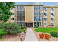 Inviting exterior of a multi-story condo building with lush landscaping and walkway at 13626 E Bates Ave # 110, Aurora, CO 80014