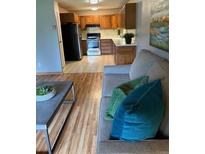 Inviting living room flows into a functional kitchen with wood cabinets and modern appliances at 13626 E Bates Ave # 110, Aurora, CO 80014