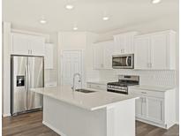 Bright kitchen with stainless steel appliances, white cabinets and island with sink at 8898 Salida St, Commerce City, CO 80022
