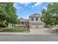 Charming home featuring a well-maintained lawn, large trees, and a two car garage at 1005 S Lewiston Way, Aurora, CO 80017