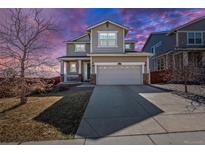 Charming two-story home with a two-car garage, covered porch, and well-maintained landscaping at sunset at 10554 Casper Pt, Parker, CO 80134