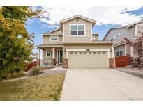 Charming two-story home boasts a welcoming porch and an attached two-car garage at 10554 Casper Pt, Parker, CO 80134