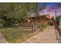 Charming single-story home with a fenced yard and covered front porch, perfect for enjoying outdoor living at 2280 S Decatur St, Denver, CO 80219