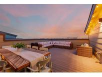 Relax on this rooftop deck with beautiful city views and a dining and lounging area at 6776 Navajo Way, Denver, CO 80221