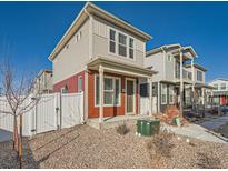 Charming two-story home with neutral siding and a cozy front porch, complemented by gravel landscaping and a white picket fence at 4987 N Walden Way, Denver, CO 80249