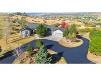 Stunning home boasts a circular driveway and professional landscaping, set against a picturesque mountain backdrop at 1967 Haystack Rd, Castle Rock, CO 80104