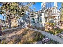 Exterior view of a well-maintained townhome with a staircase and landscaped front yard at 4084 S Carson St # A, Aurora, CO 80014