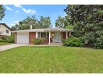 Charming brick home featuring a well-manicured front lawn and attached one car garage at 8304 Eaton Way, Arvada, CO 80003