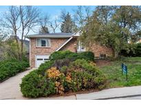 Charming brick home with an attached garage, mature landscaping, and a well-maintained front yard at 2015 Arapahoe St, Golden, CO 80401