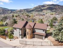 Beautiful two-story home boasts unique stone turret, mature trees, and mountain views at 600 Cascade Dr, Golden, CO 80403