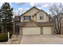 Two-story home with a two car garage, light tan siding and a brick facade at 9946 Wyecliff Dr, Highlands Ranch, CO 80126