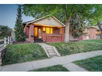 Charming brick home featuring a cozy front porch and manicured lawn, perfect for relaxation at 1866 S Pennsylvania St, Denver, CO 80210