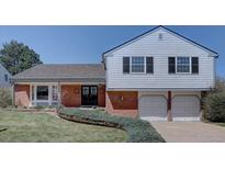 Charming home featuring a well-manicured lawn, brick accents, and an attached two-car garage at 5759 E Geddes Cir, Centennial, CO 80112
