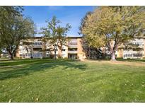 Spacious condo building with well-maintained lawn and mature trees offering serene outdoor living at 750 S Clinton St # 6B, Denver, CO 80247