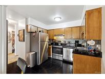 Galley kitchen featuring stainless steel appliances and dark tiled floor at 750 S Clinton St # 6B, Denver, CO 80247