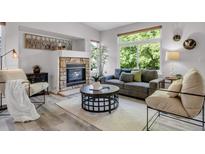 Cozy living room with stone fireplace, large windows and comfortable seating area at 11585 Decatur St # B, Denver, CO 80234