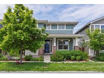 Charming two-story home with well-manicured landscaping, colorful flowerbeds, and mature trees at 5445 Verbena St, Denver, CO 80238